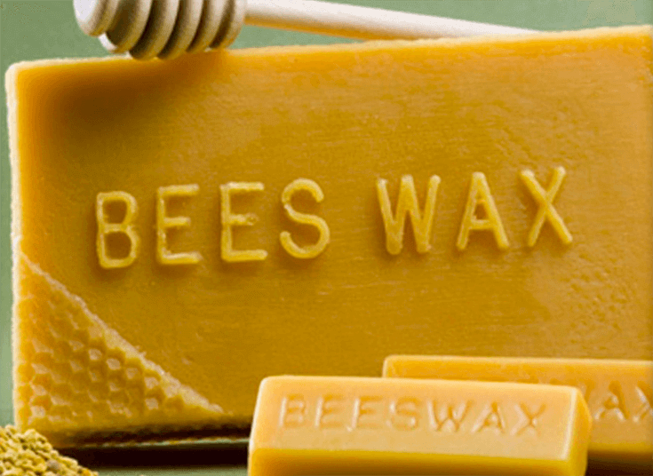 enlarged photo of a yellow rectangular slab of beeswax with the words Bees Wax embossed on the front.