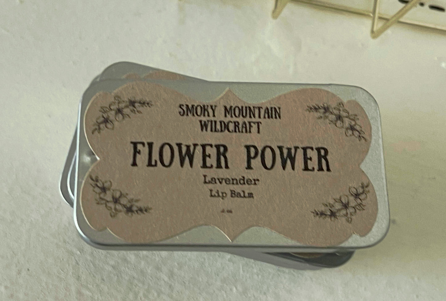A view from the top of a silver tin containing an all organic lip balm. 