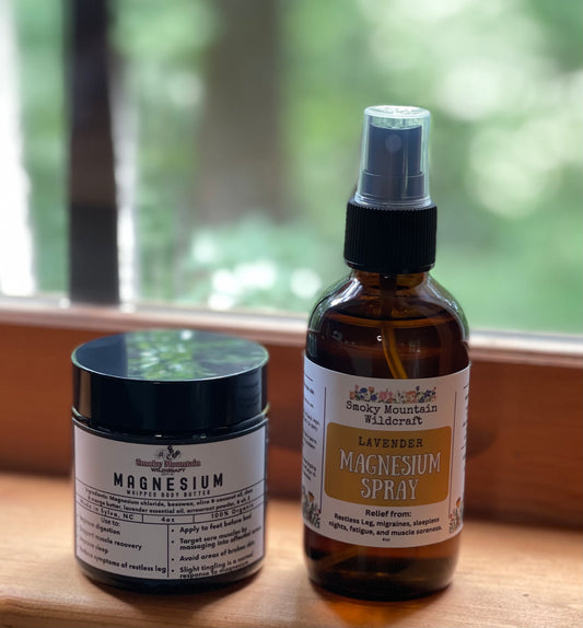 Magnesium products in an amber spray bottle and amber jar with white labels on a wooden surface, blurred greenery in the background.